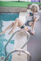 A woman in a maid outfit sitting on the edge of a swimming pool.