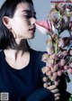 A woman holding a bunch of flowers in her hand.