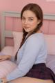 A young woman sitting on top of a bed.