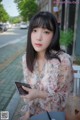 A woman sitting at a table with a cell phone in her hand.