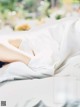 A woman laying on a bed covered in white sheets.