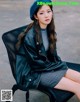 A woman sitting on a chair wearing a blue beret.