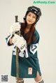 A woman in a hockey uniform holding a hockey stick.