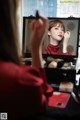 A woman is looking at her reflection in a mirror.