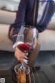 A woman sitting on a couch holding a glass of red wine.