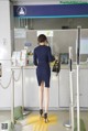 A woman in a blue dress standing in front of a counter.