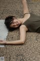 A woman laying on the ground with her arms outstretched.